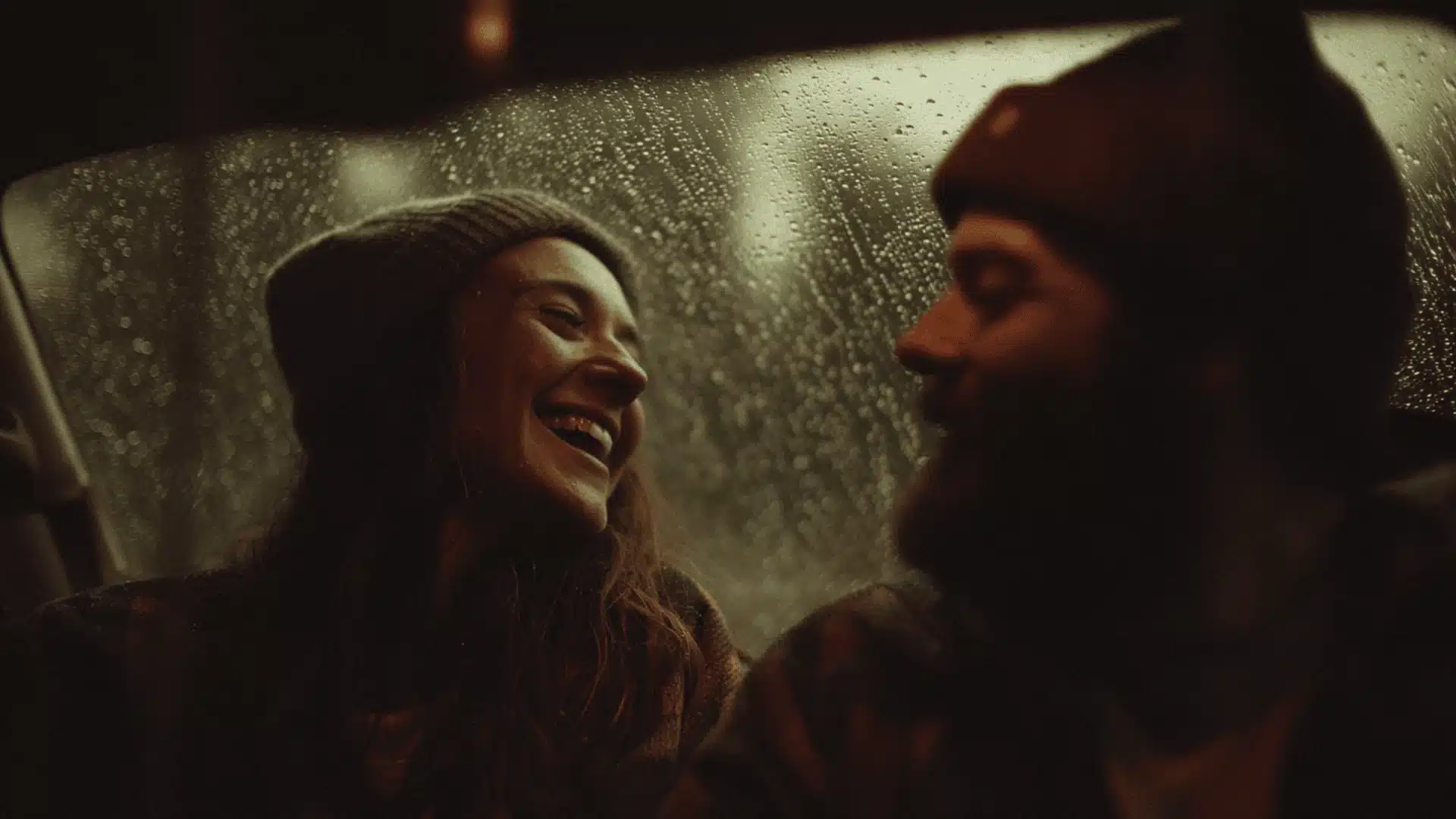 A dimly lit image shows a couple inside a vehicle during a rain shower