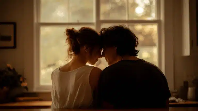 A man and woman sharing a quiet moment of intimacy reflecting the 5 stepping stones in a relationship with foreheads touching in soft warm light indoors