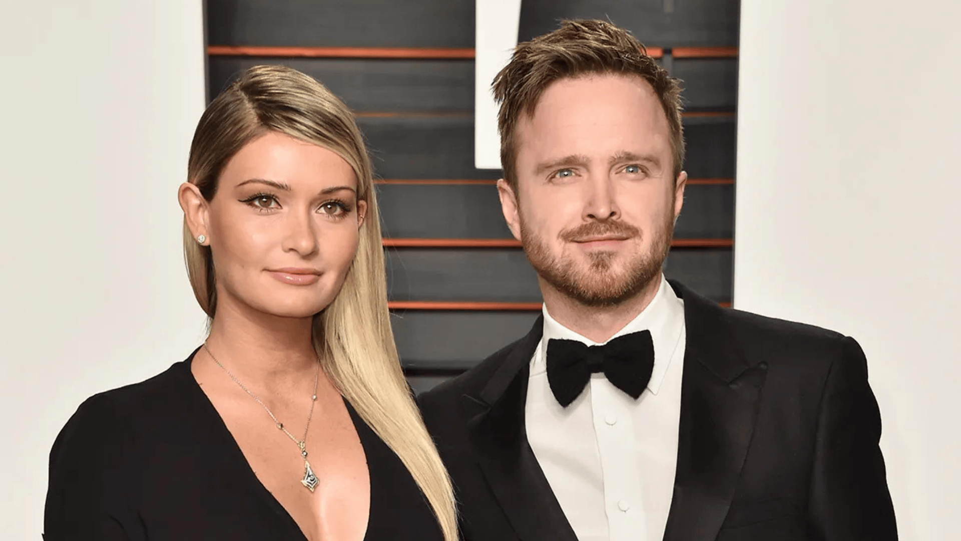 Aaron Paul and Lauren Parsekian attend the 2015 Vanity Fair Oscar Party. He wears a tuxedo while she is in a black dress