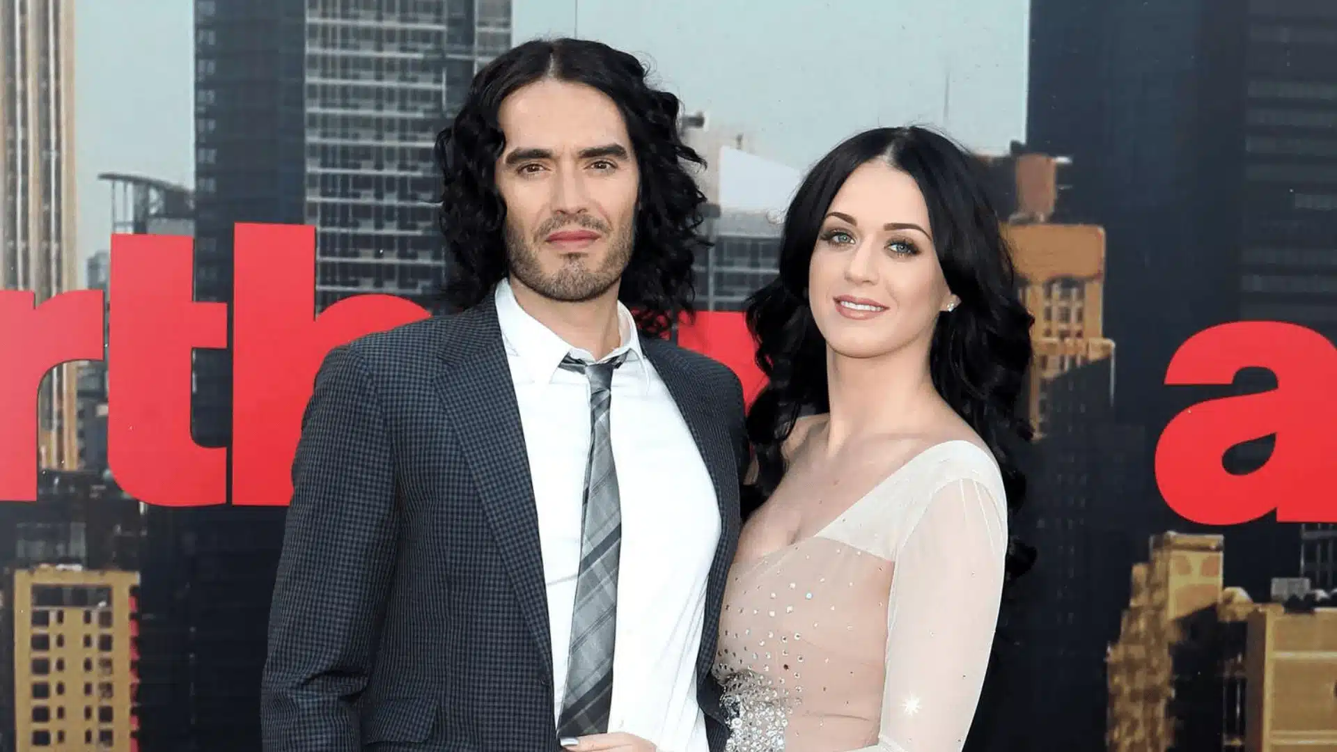 Russell Brand and Katy Perry pose together, showcasing their Scorpio and Gemini connection, with stylish outfits and a joyful moment