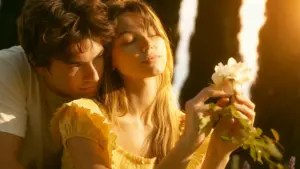 Young couple embracing in golden sunlight as the woman holds a white flower to show the deep emotional bond of real love