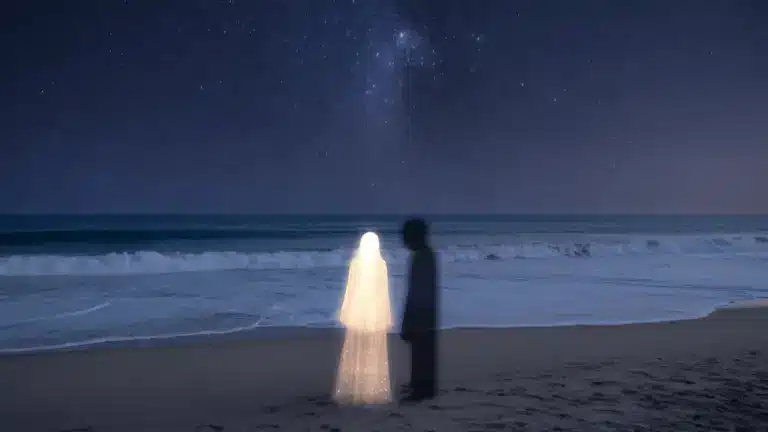 Glowing figure and shadowy partner stand on beach under starry sky with waves in background