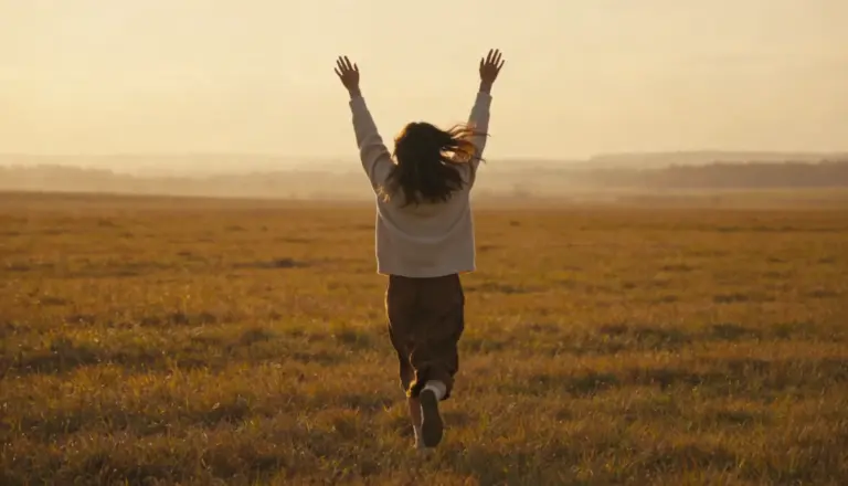 A woman running freely in a sunlit field at sunset, and the freedom is what you get with a balanced atopobium vaginae in your life