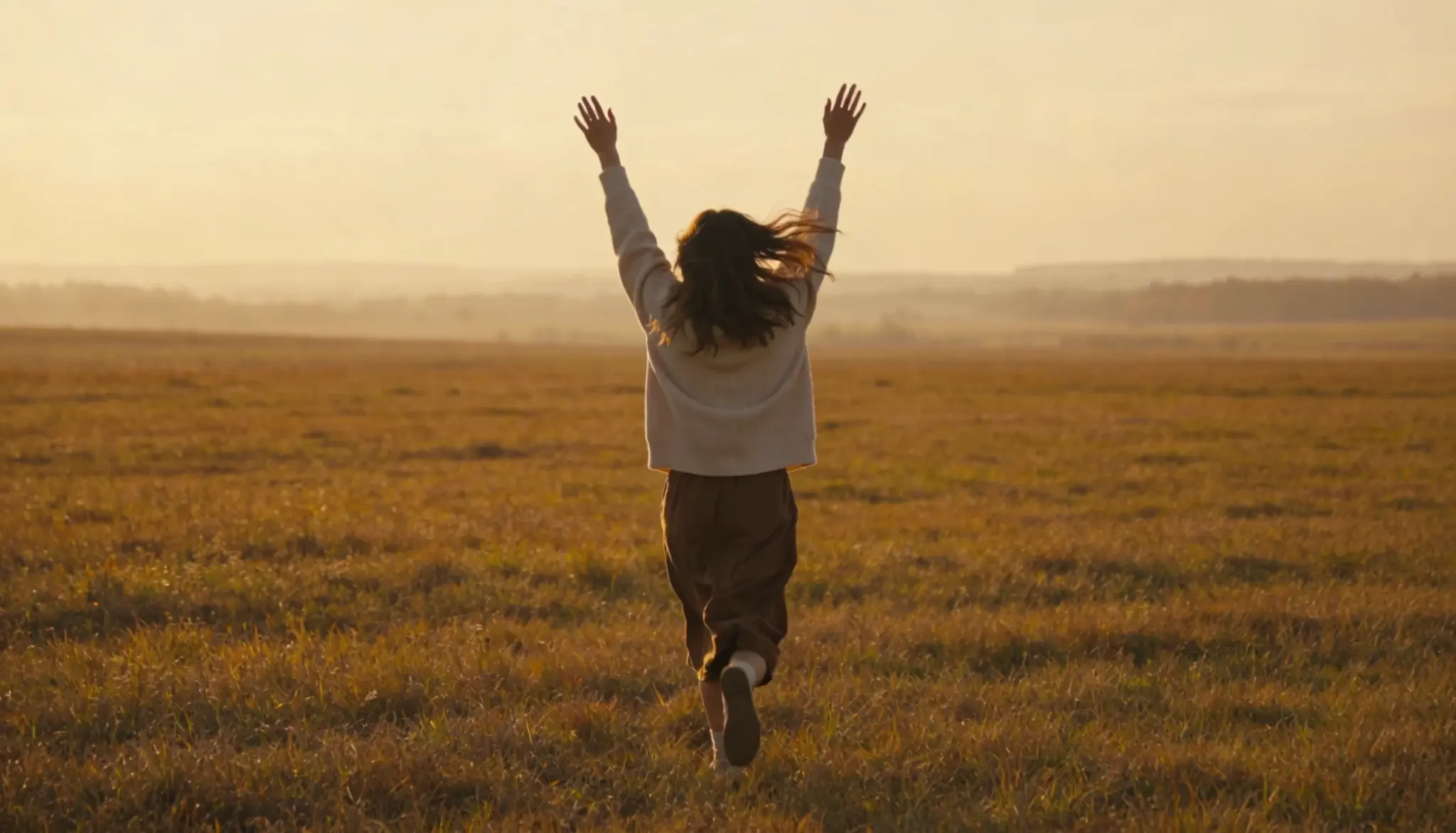 A woman running freely in a sunlit field at sunset, and the freedom is what you get with a balanced atopobium vaginae in your life