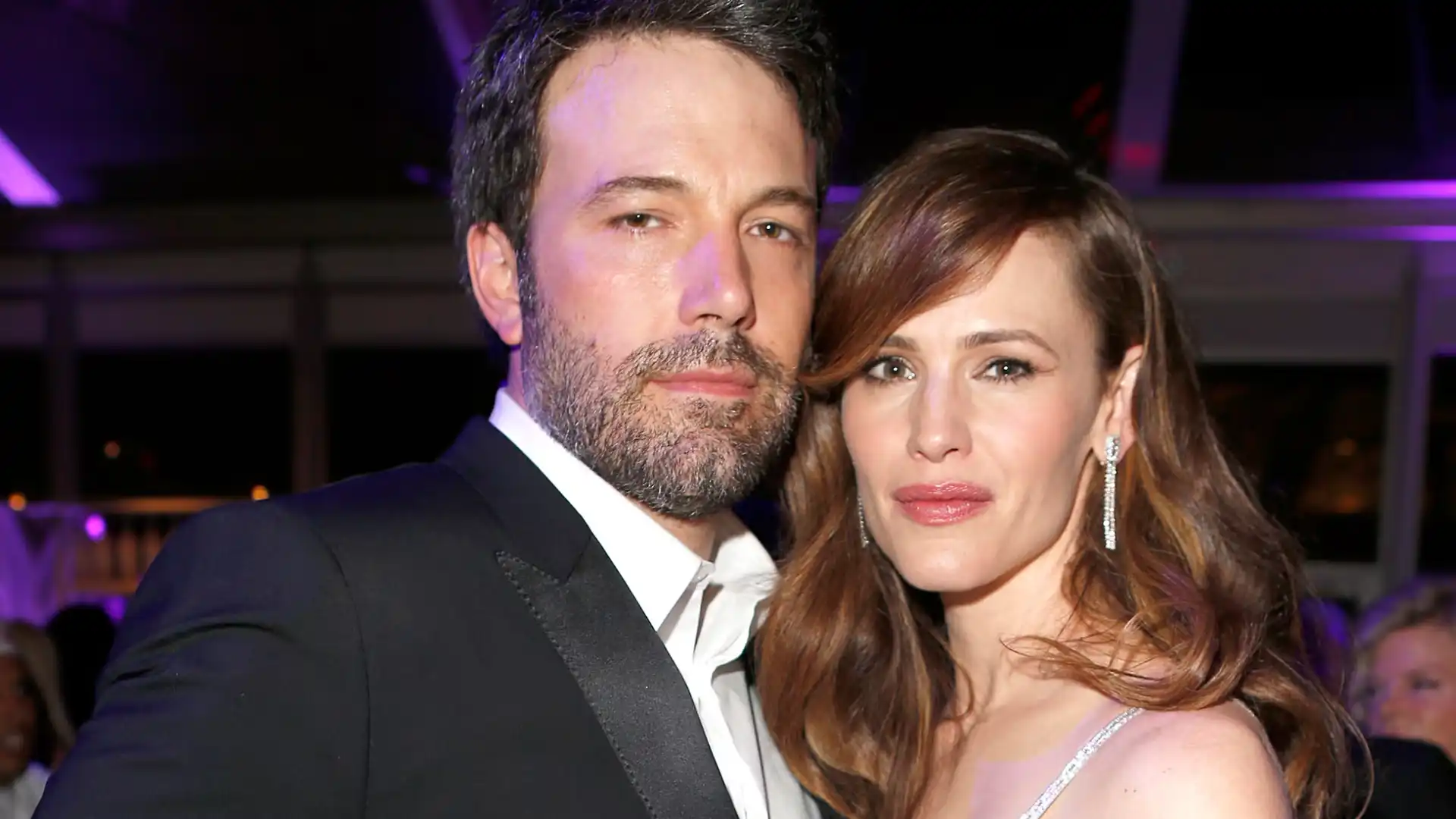 Ben Affleck and Jennifer Garner pose together closely at a formal evening event under purple lighting.