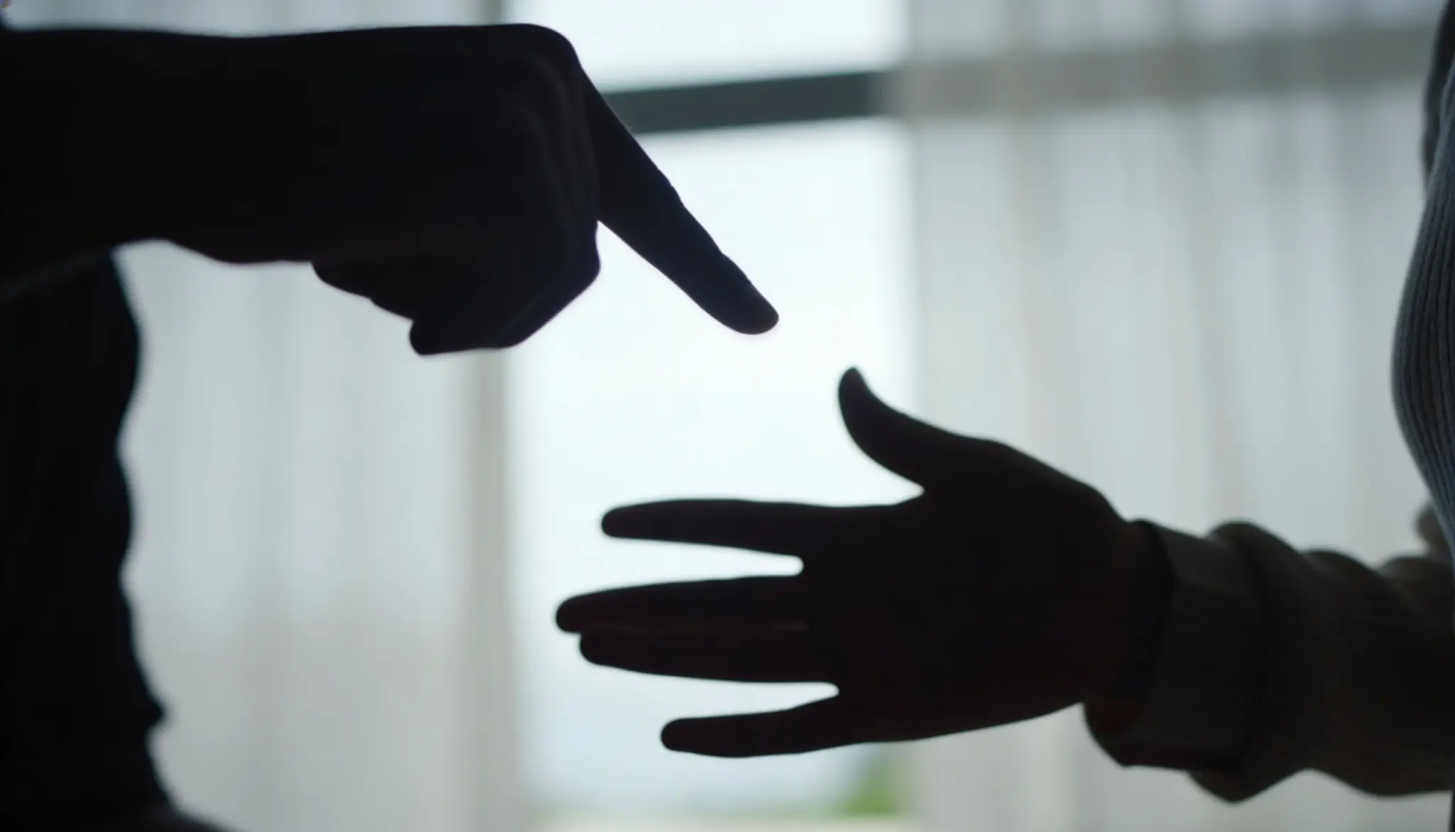 Silhouette of a man pointing accusingly at a woman during a tense argument, depicting narcissistic behavior in a relationship