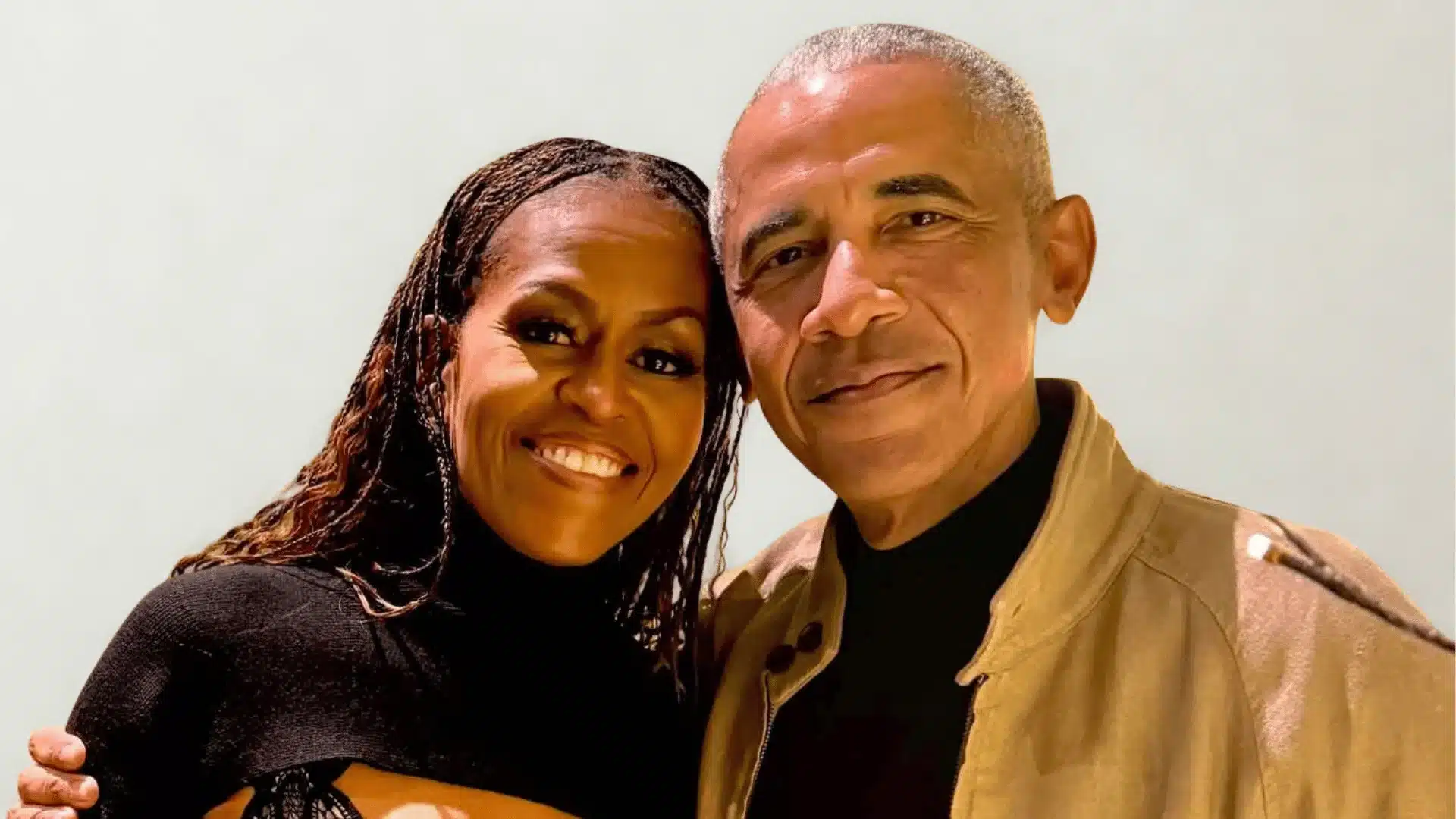 Barack Obama and Michelle Obama smile at the camera.
