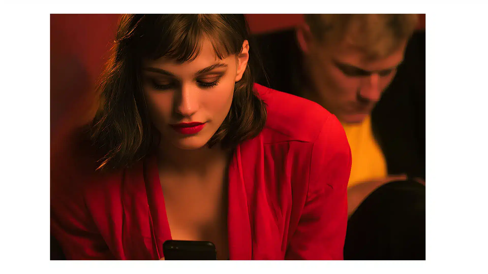 A woman gazes intently at her smartphone, deeply absorbed in its screen, completely lost in the digital world.